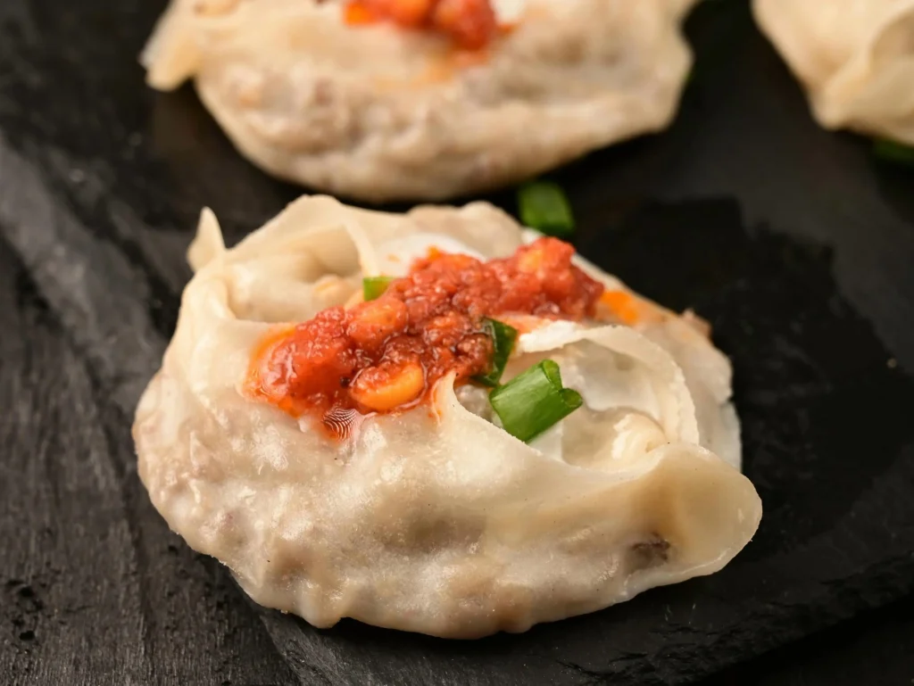 photo of mantu dumplings with tomato sauce