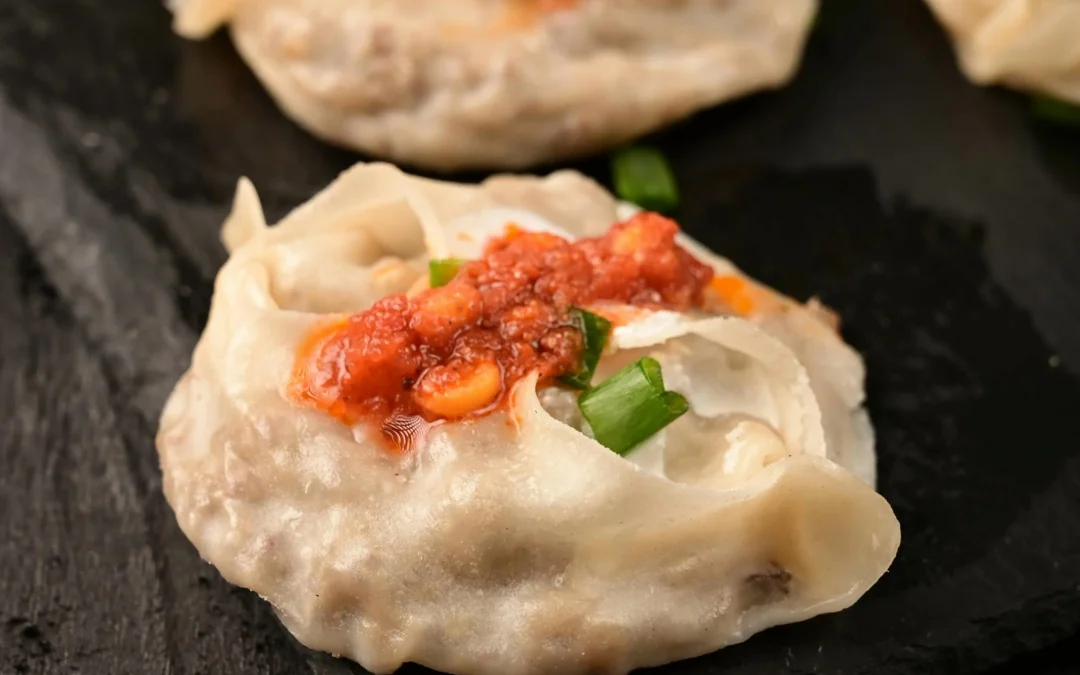 photo of mantu dumplings with tomato sauce