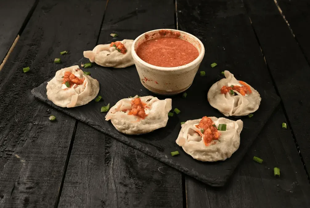 photo of mantu dumplings with tomato sauce