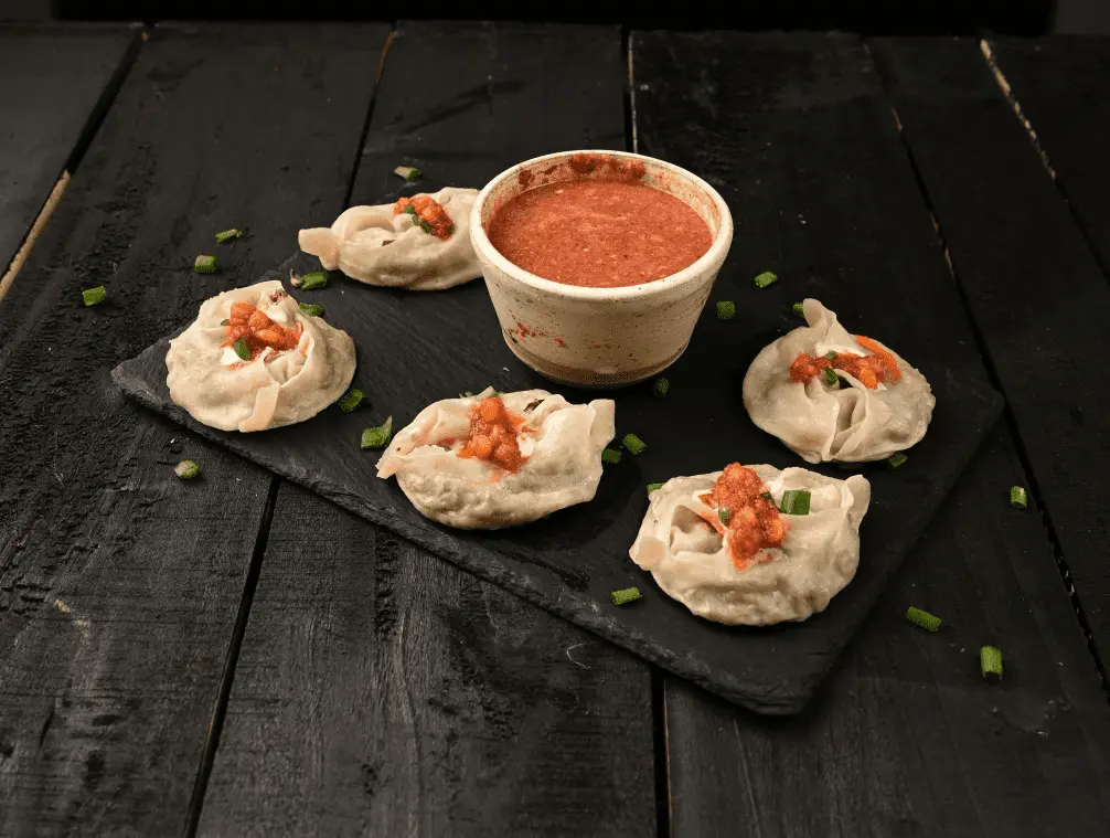 photo of mantu dumplings with tomato sauce