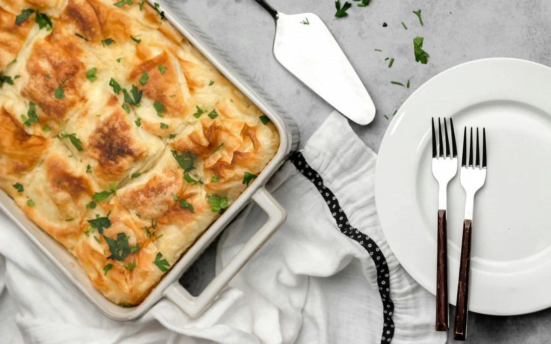 Spanakopita in a baking dish next to a plate